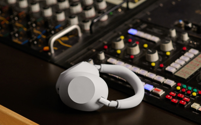 Sony WH-1000XM6 headphones beside a studio mixing console